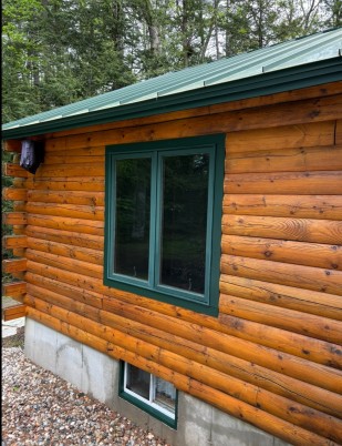 Clean gutters on a Maine log cabin